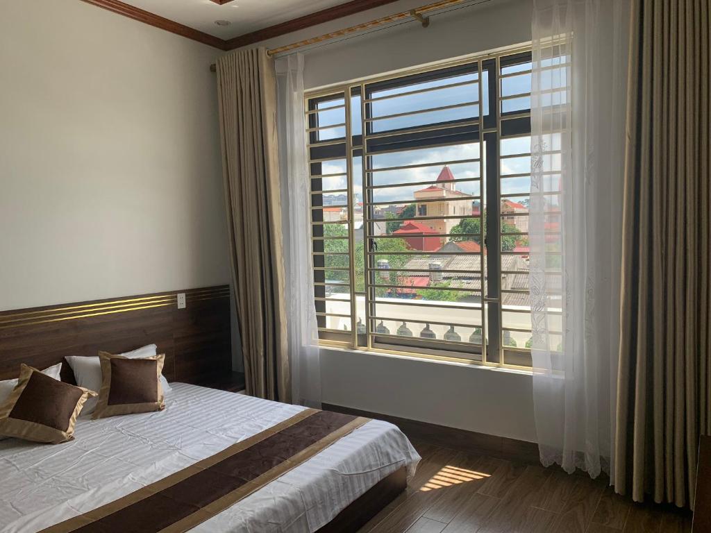 una camera da letto con un letto e una grande finestra di Khách sạn Ánh Trăng a Lạng Sơn