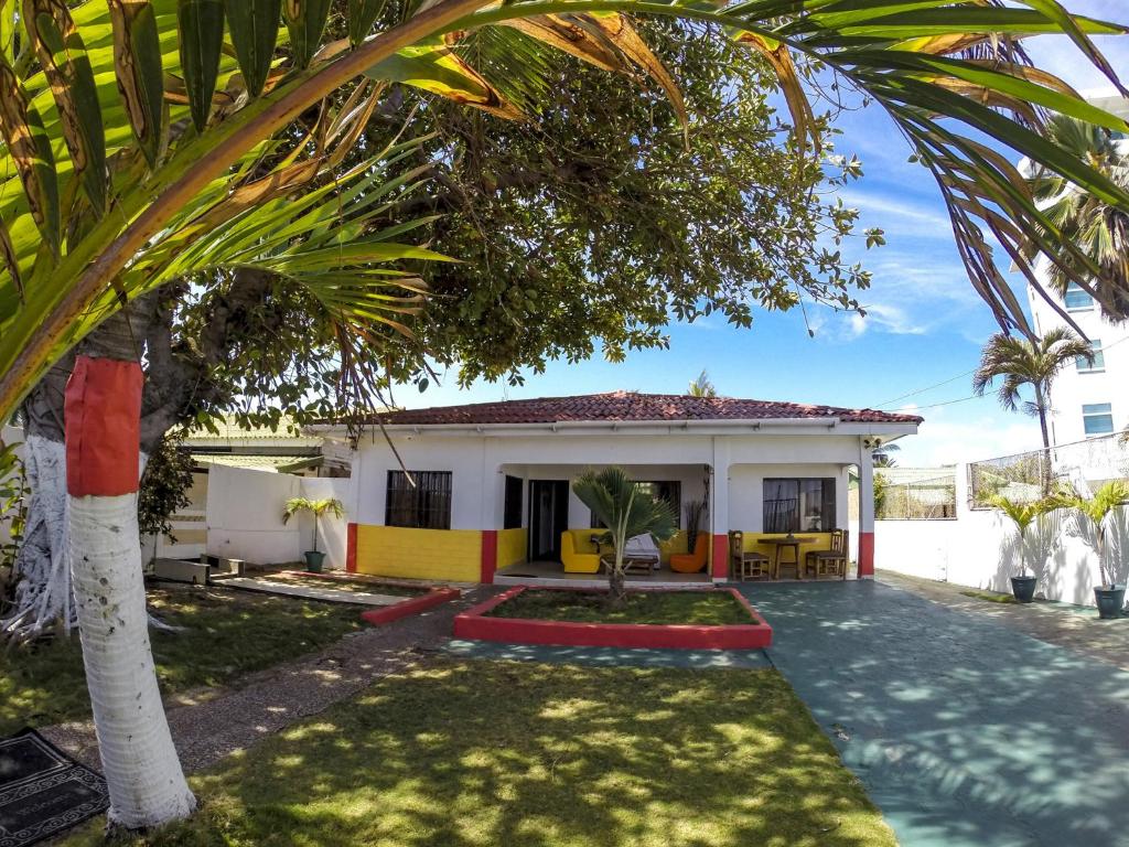 a house with a palm tree in front of it at Villa Sarie Bay in San Andrés