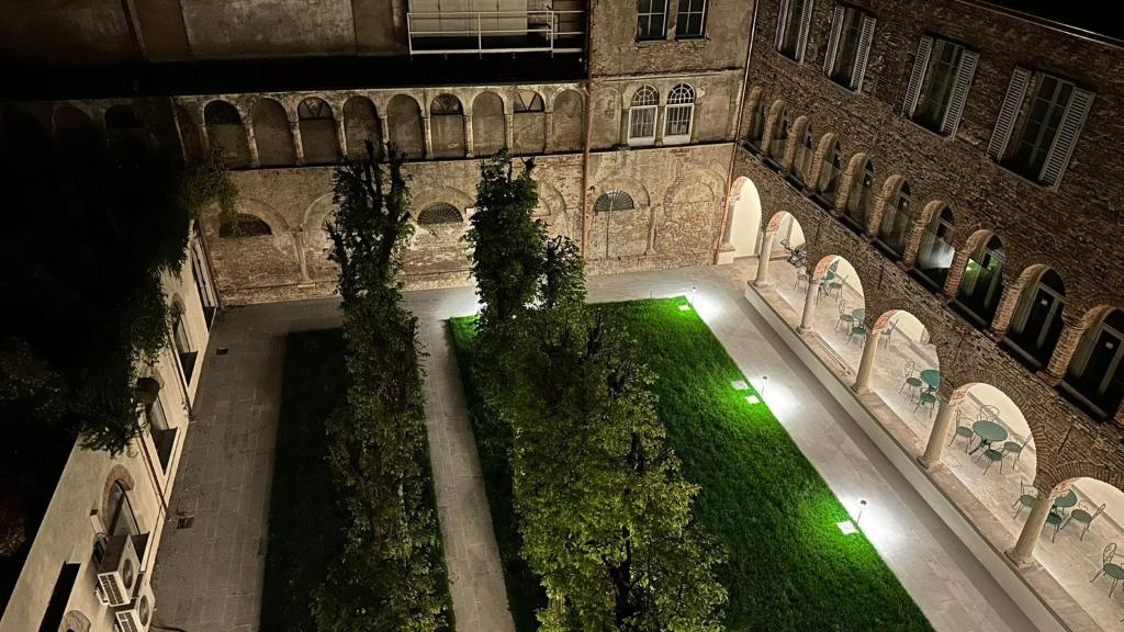 an indoor courtyard with a green lawn in a building at Palazzo Santo Spirito in Bergamo