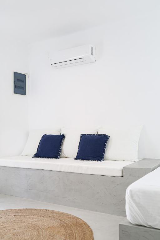 białą kanapę z dwoma niebieskimi poduszkami w obiekcie 30villa Rd Studio w mieście Rodos