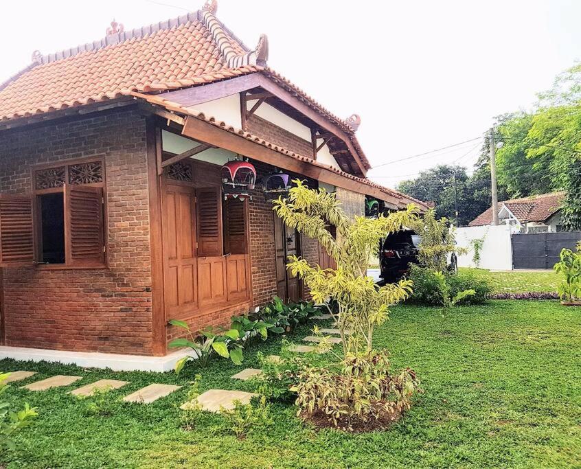 ボゴールにあるnDalem Julang Bogor - Javanese House 2Bedroomの庭に木のある小さなレンガ造りの家