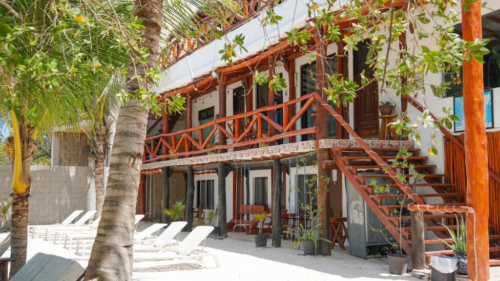 a building with a staircase and a bunch of chairs at Choby's House Holbox in Holbox Island