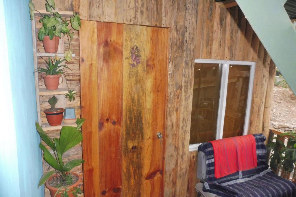 a room with a wooden door and some plants at Casa Deja-vu in San Marcos La Laguna