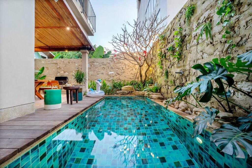 een zwembad voor een stenen muur bij Maycasa Villa - Private pool 4BR in Da Nang