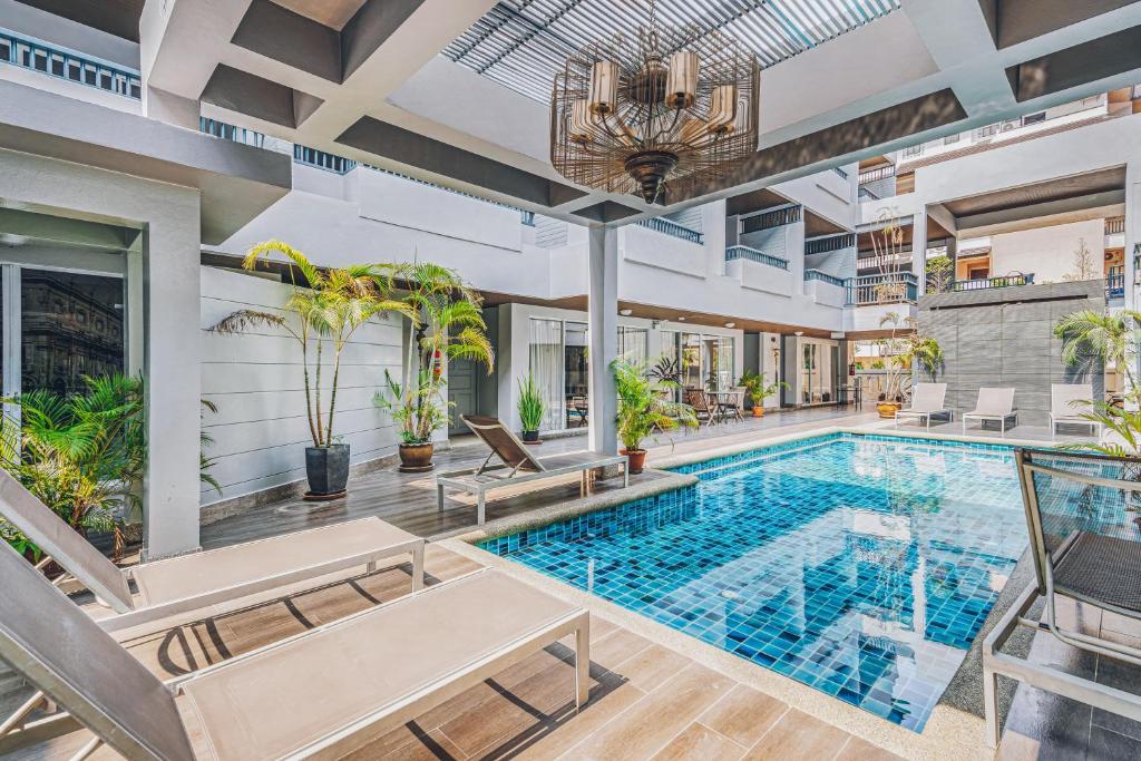 an indoor pool in a house with chairs and a table at The Dale Pattaya Boutique and Spa in Pattaya South