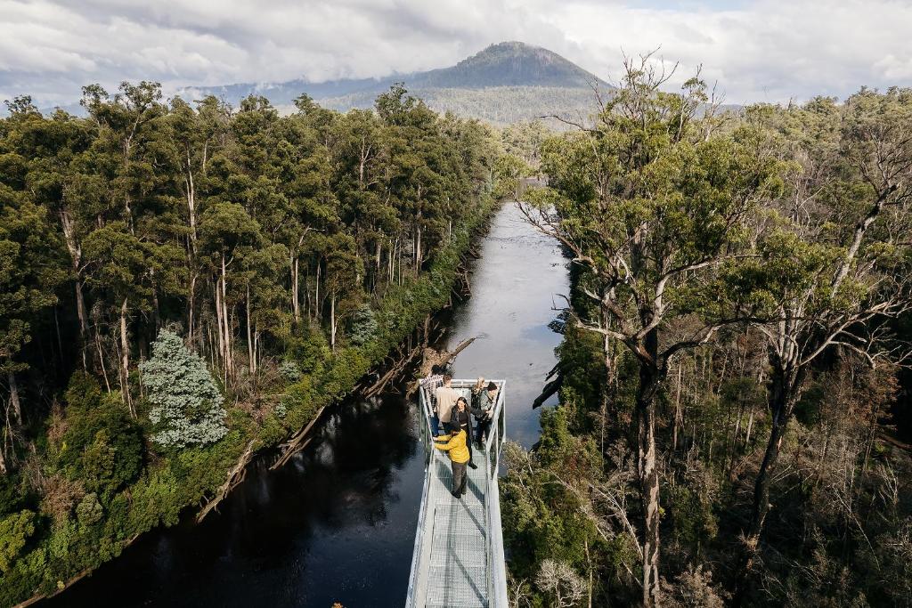 a boat on a bridge over a river with a mountain at Tahune AirWalk Cabin and Lodge in Geeveston
