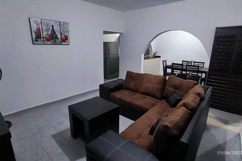 a living room with a brown couch and a table at Casa cómoda en Tuxtla Gutiérrez in Tuxtla Gutiérrez