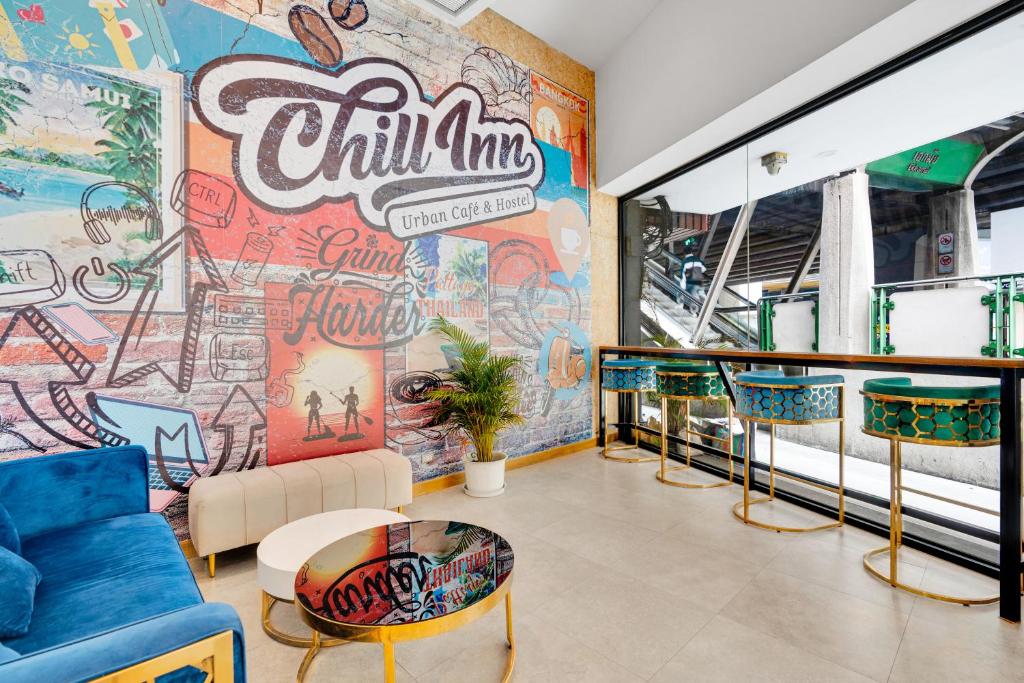 una sala de estar con una pared cubierta de graffiti en Chill Inn Bangkok en Bang Kapi