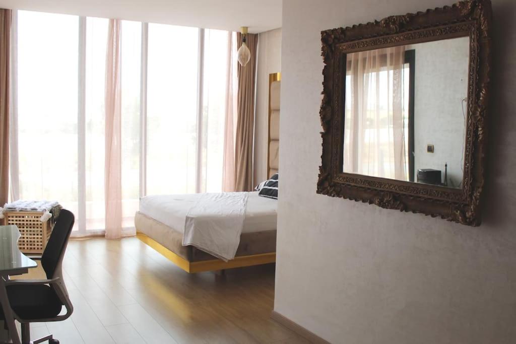 um quarto com uma cama e um espelho na parede em Villa à bahia golf beach em Kasba Bou Hamira