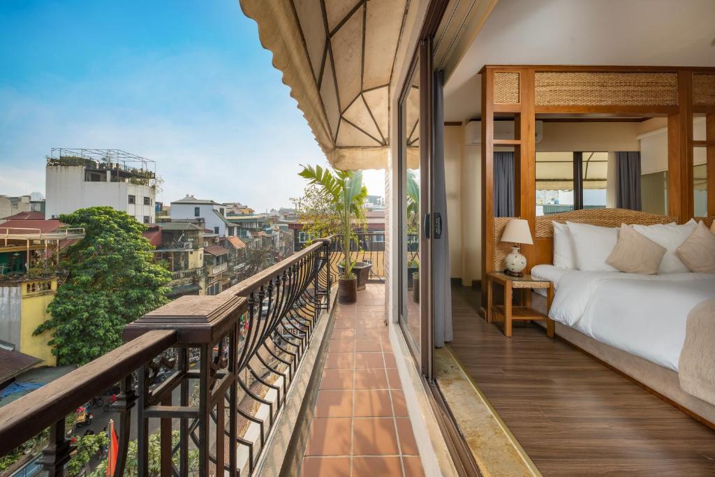 een balkon van een hotelkamer met een bed en uitzicht bij MK Premier Boutique Hotel in Hanoi