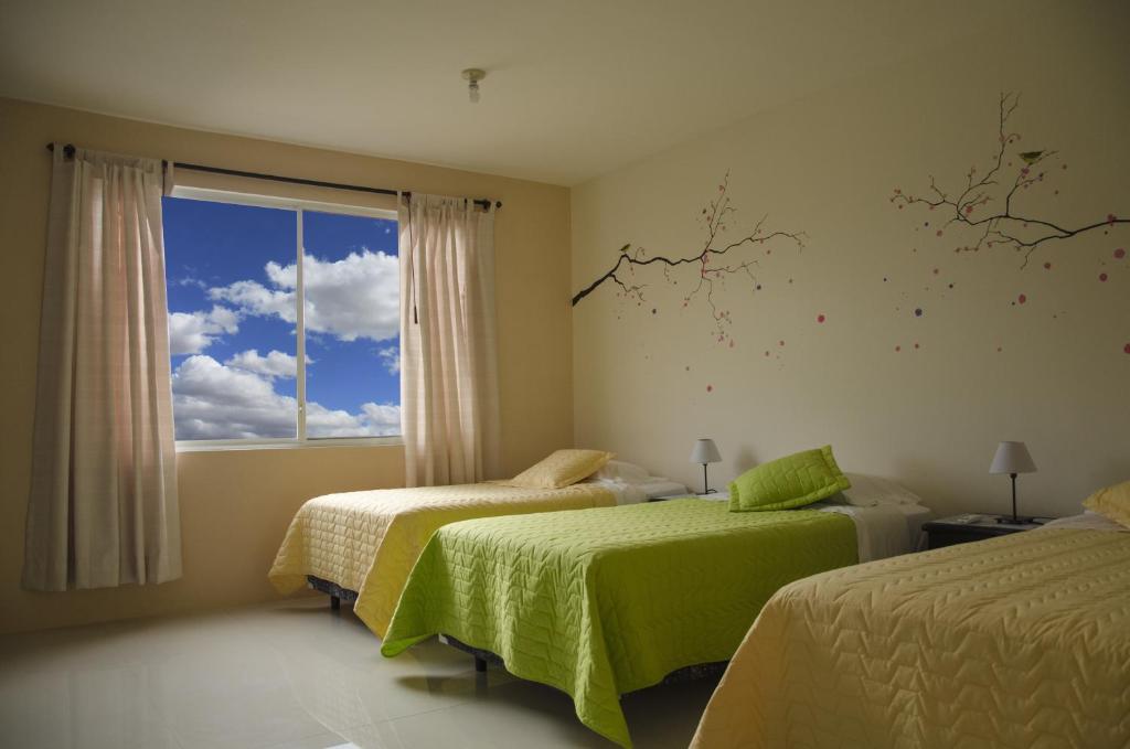 阿約拉港的住宿－加拉帕戈斯海洋之夢旅舍，一间卧室设有两张床和窗户。