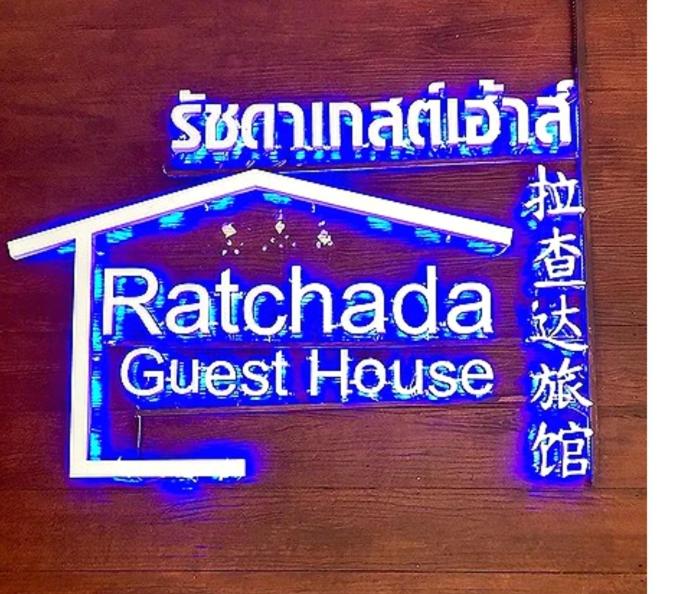 a sign for a restaurant with a guest house at Ratchada Guesthouse in Bangkok