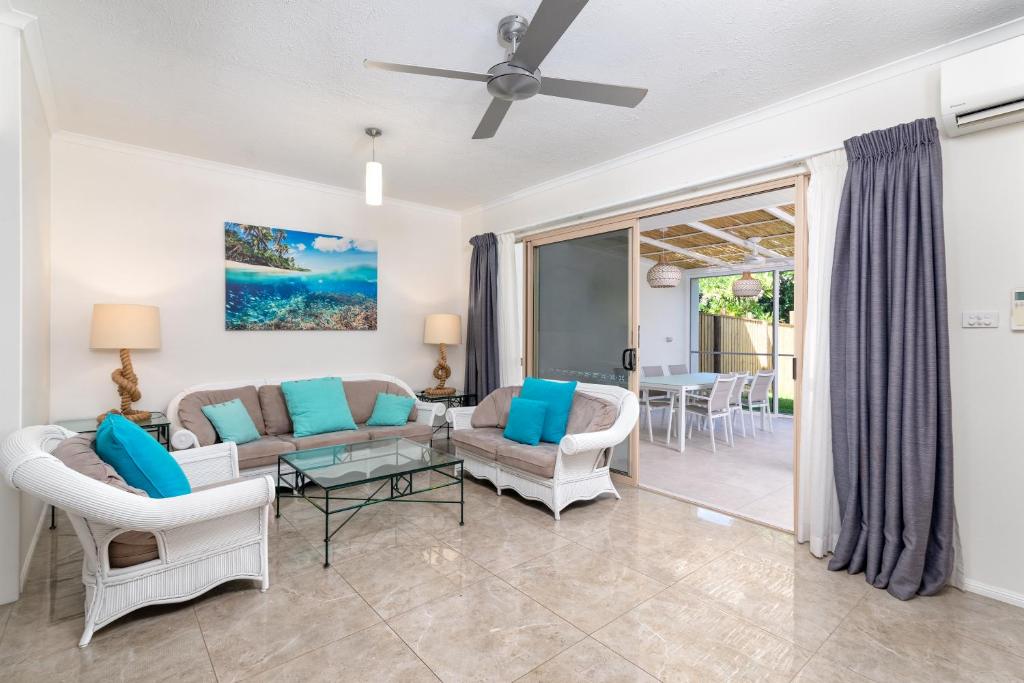 a living room with a couch and chairs at Seascape Holidays at Reef Terraces on St Crispins in Port Douglas