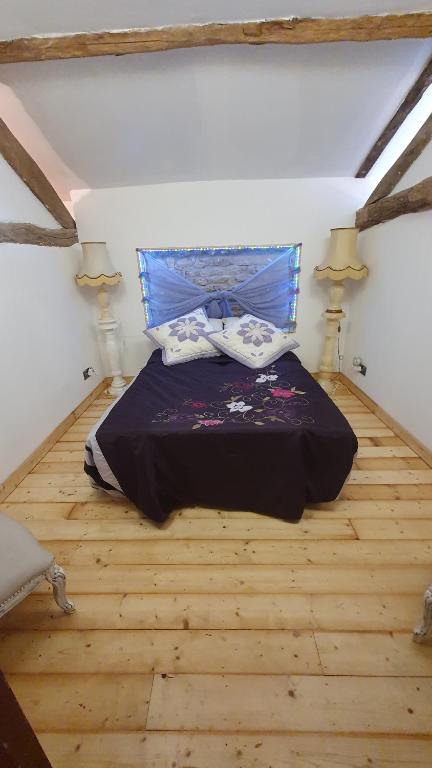 a bedroom with a bed in a attic with two lamps at Chateau Mano in Mairé-lʼEveseault