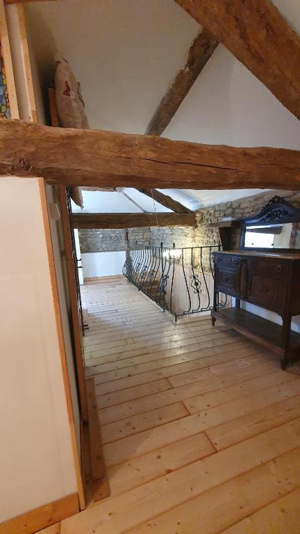 an attic room with a wooden floor and a piano at Chateau Mano in Mairé-lʼEveseault
