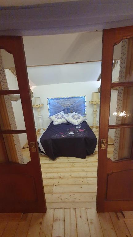 a bed in a room with two open doors at Chateau Mano in Mairé-lʼEveseault