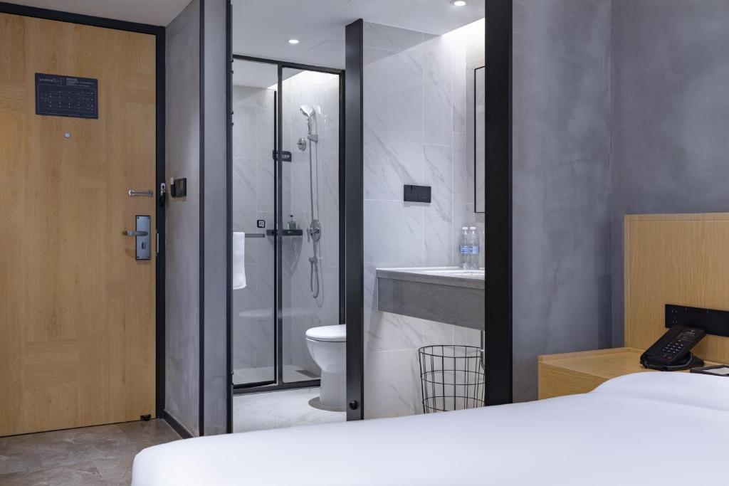 a bathroom with a shower and a toilet and a sink at Tuke China Hotel -Wenzhou South Bus Terminal in Wenzhou