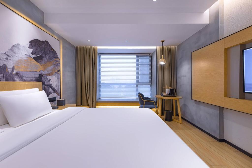 a bedroom with a large bed and a tv at Tuke China Hotel -Wenzhou South Bus Terminal in Wenzhou