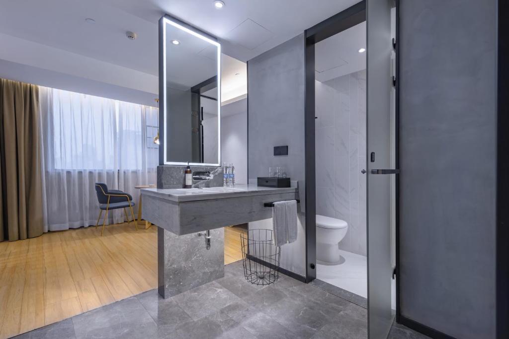 a bathroom with a sink and a toilet and a mirror at Tuke China Hotel -Wenzhou South Bus Terminal in Wenzhou