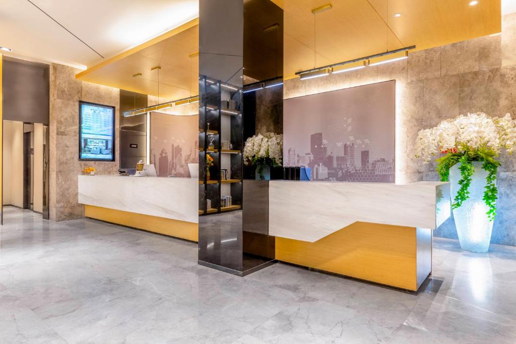 a lobby with a reception desk with flowers on it at Tuke China Hotel -Wenzhou South Bus Terminal in Wenzhou