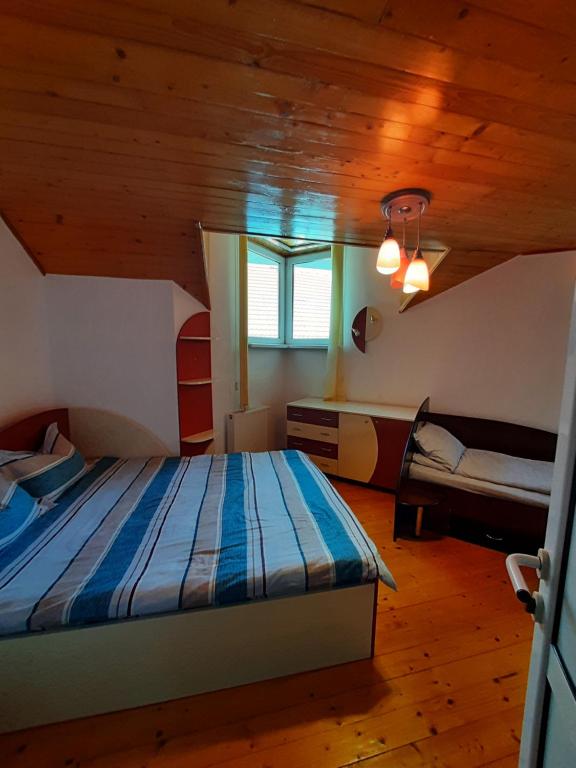 a bedroom with a bed in a room with wooden ceilings at Casa Jax in Rîmeţi