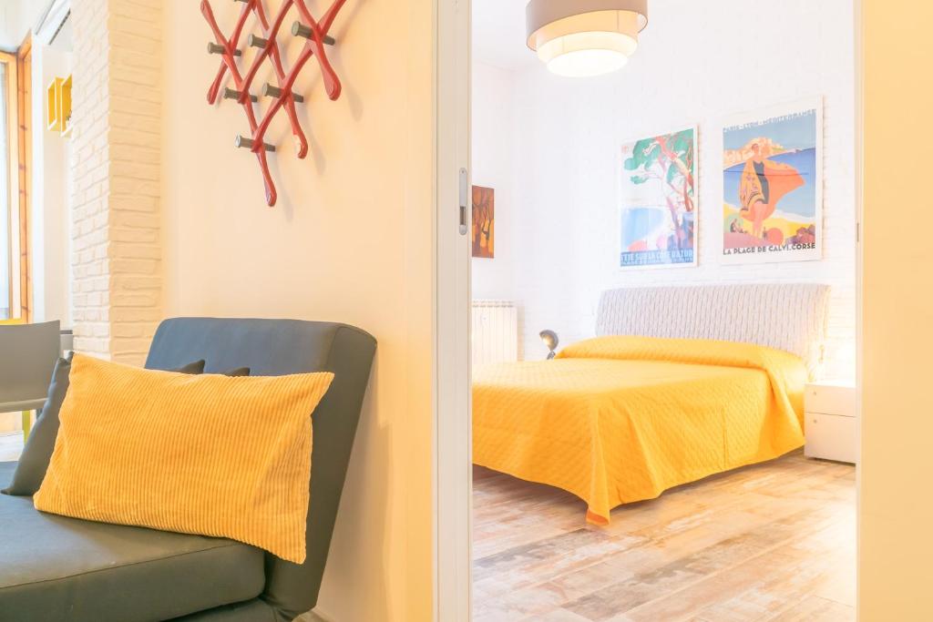 een slaapkamer met een bed en een stoel met een gele deken bij Casa Vanoli in La Spezia