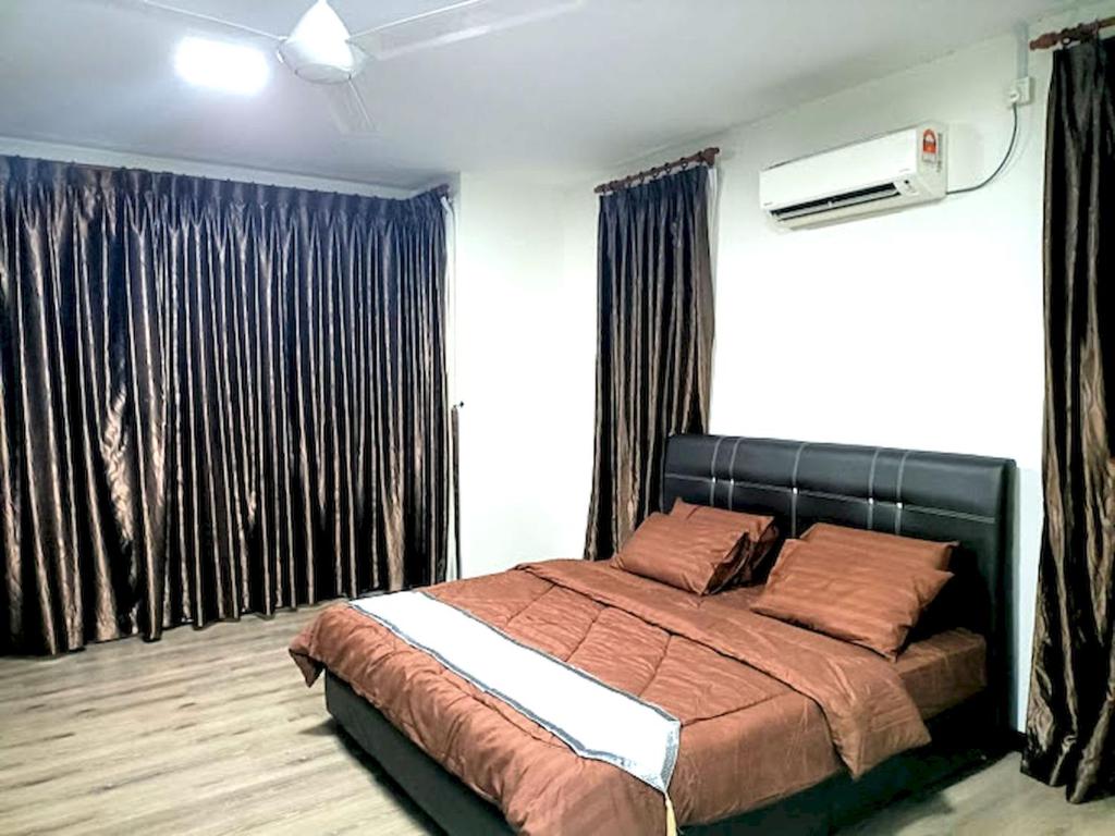 ein Schlafzimmer mit einem großen Bett und Vorhängen in der Unterkunft OYO HOME 90768 Flo Inn Motel in Tawau