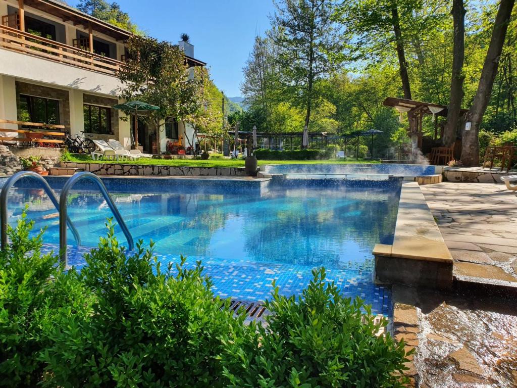a swimming pool with a fountain in a yard at Family Hotel BOHEMA in Ognyanovo