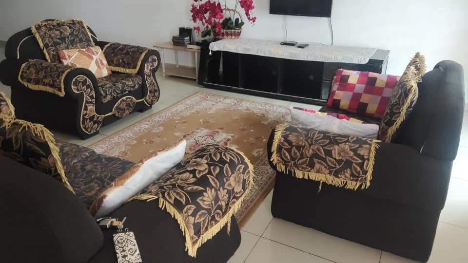 a living room with two chairs and a couch at Penang holiday villa in Jelutong
