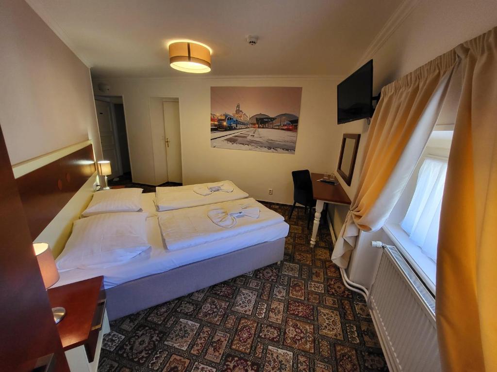 Pokój hotelowy z łóżkiem, biurkiem i oknem w obiekcie City-Inn w Pradze