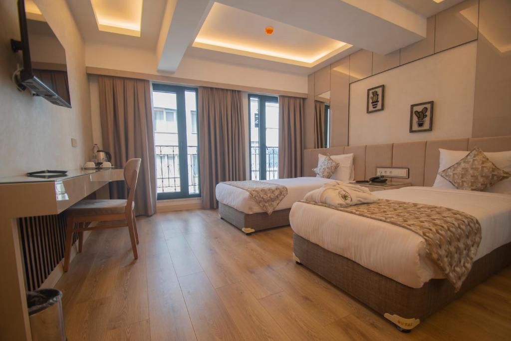 Cette chambre comprend deux lits et un bureau. dans l'établissement Vera Life Hotel, à Istanbul