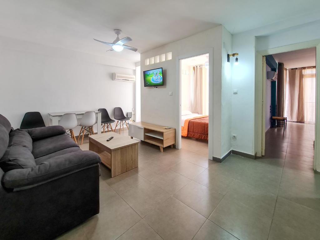 een woonkamer met een bank en een kamer met een bed bij Apartamento Completo Vera Rincon de Loix in Benidorm