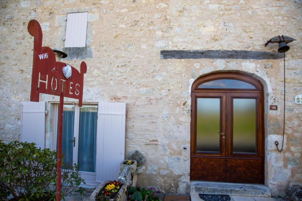 budynek z drzwiami i znakiem dla hotelu w obiekcie L'Esprit du 24 w mieście Rouffignac-de-Sigoulès
