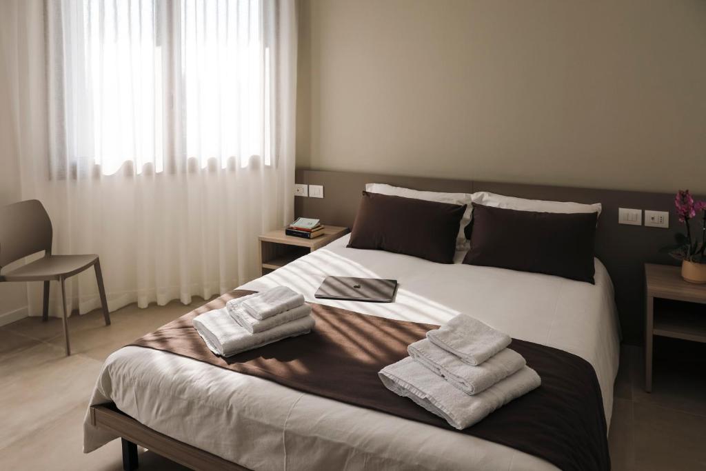 sypialnia z dużym łóżkiem z ręcznikami w obiekcie Alloggi alla Rotonda 