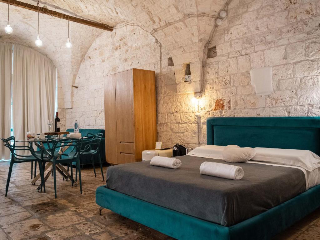 a bedroom with a bed and a table with chairs at Dama Bianca Boutique Hotel Ostuni in Ostuni