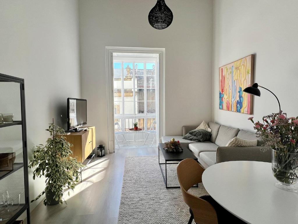 a living room with a couch and a table at Apartamento Duplex casa Palacio rehabilitado centro El Puerto in El Puerto de Santa María