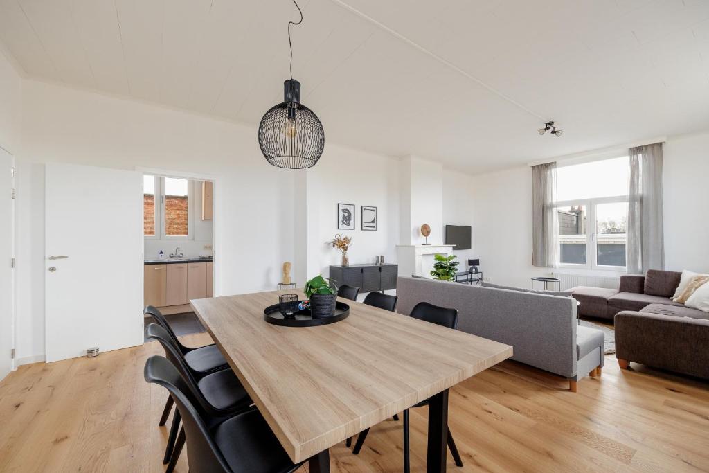 - une salle à manger et un salon avec une table et des chaises dans l'établissement SurPRIMO - Gerenoveerd appartement, à Anvers