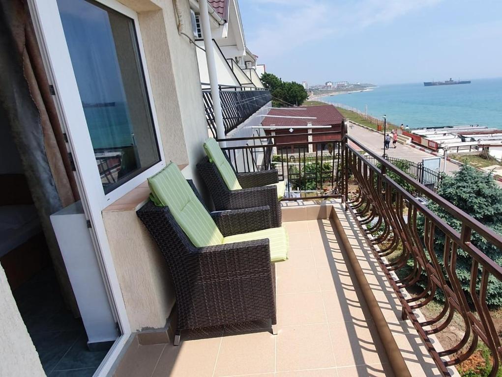 een balkon met 2 stoelen en uitzicht op de oceaan bij Vila Jolie in Costinesti