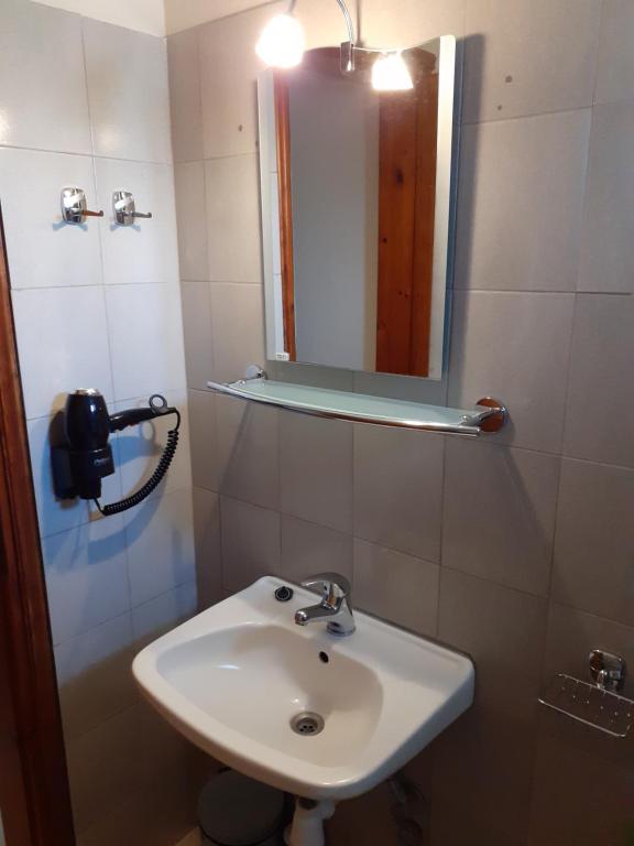 uma casa de banho com um lavatório e um espelho em Xrysafis Apartments em Nea Vrasna