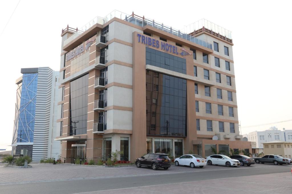 a hotel building with cars parked in front of it at Tribes hotel in Sohar