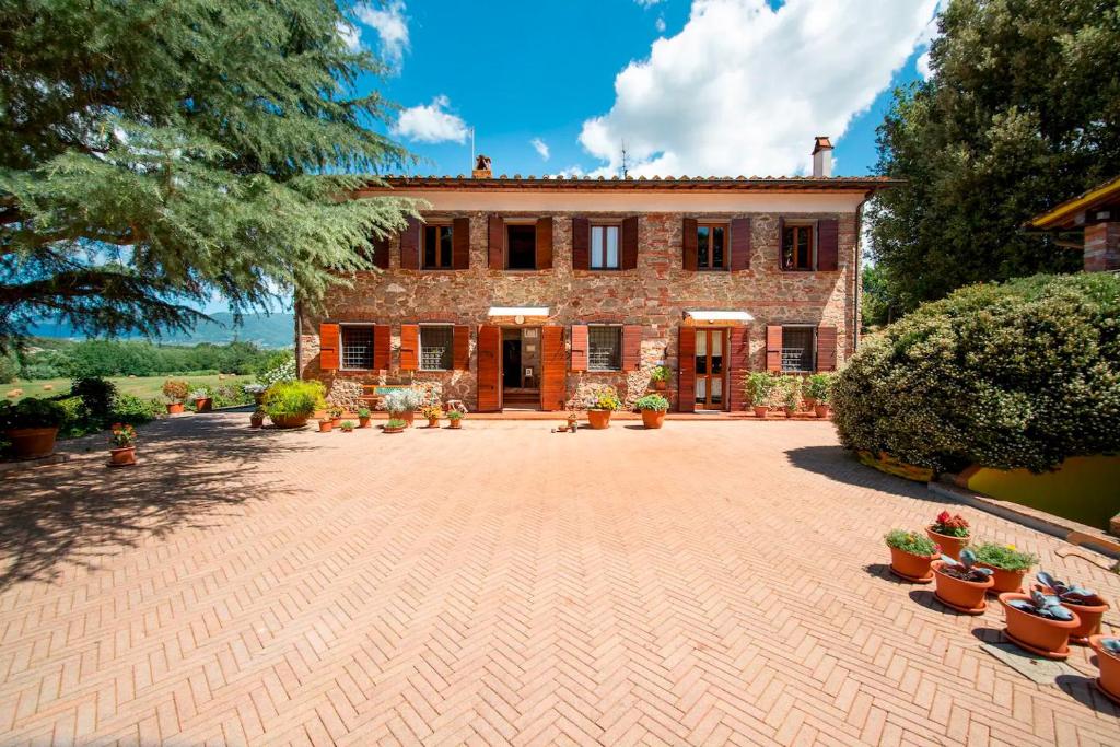 a large brick house with a large courtyard at Casolare oltre il Cielo with Swimming Pool in Porcari
