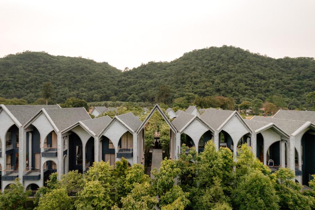 una fila di case con montagne sullo sfondo di Hotel Labaris Khao Yai a Mu Si