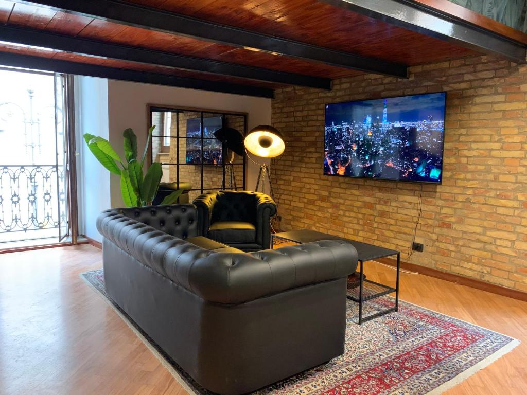 福賈的住宿－Residence Bruno，客厅配有真皮沙发和电视
