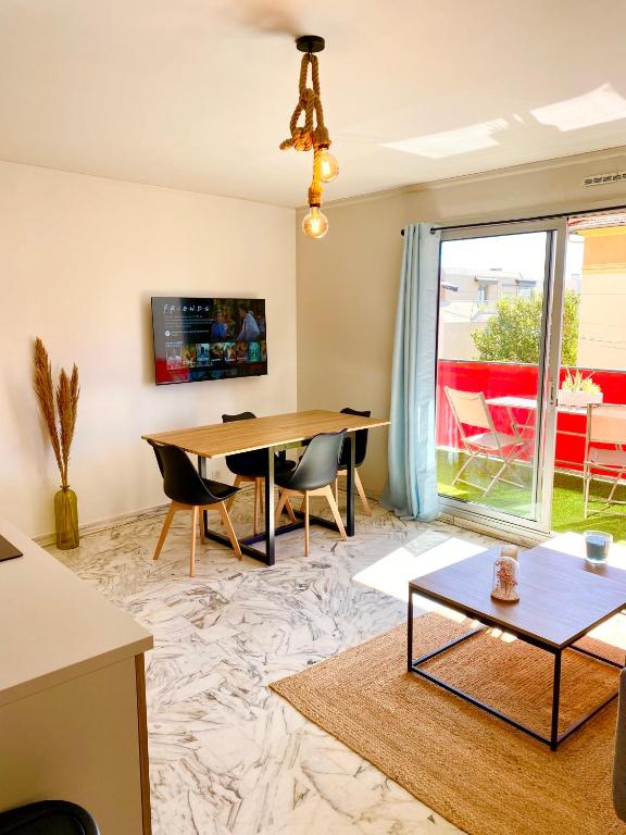 un salon avec une table et des chaises en bois dans l'établissement Superbe 3P à 300m de la plage !, à Nice