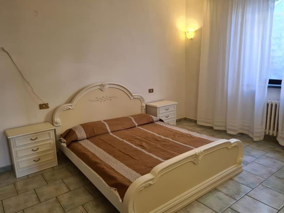 sypialnia z dużym łóżkiem i 2 szafkami nocnymi w obiekcie Appartamento con giardino w mieście Pomarance