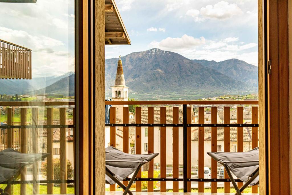 einen Balkon mit Blick auf eine Kirche und die Berge in der Unterkunft 2 Camere Panoramico nelle Dolomiti Bellunesi in Pedavena