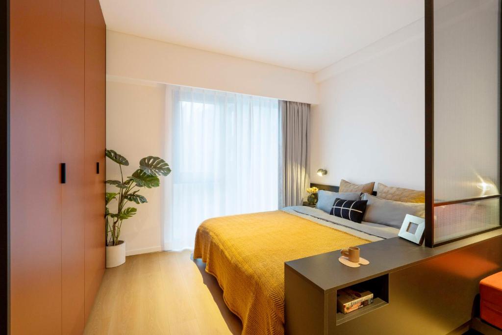 a hotel room with a bed and a mirror at base-Beijing Wangfujing Serviced Apartment- in Hutong &Bike rental &Close to Forbidden City, Tian'anmen Square &Subway nearby &Free coffee &Washing machine,Kitchen &Restaurant discount &English speaking &High speed free WiFi in Beijing