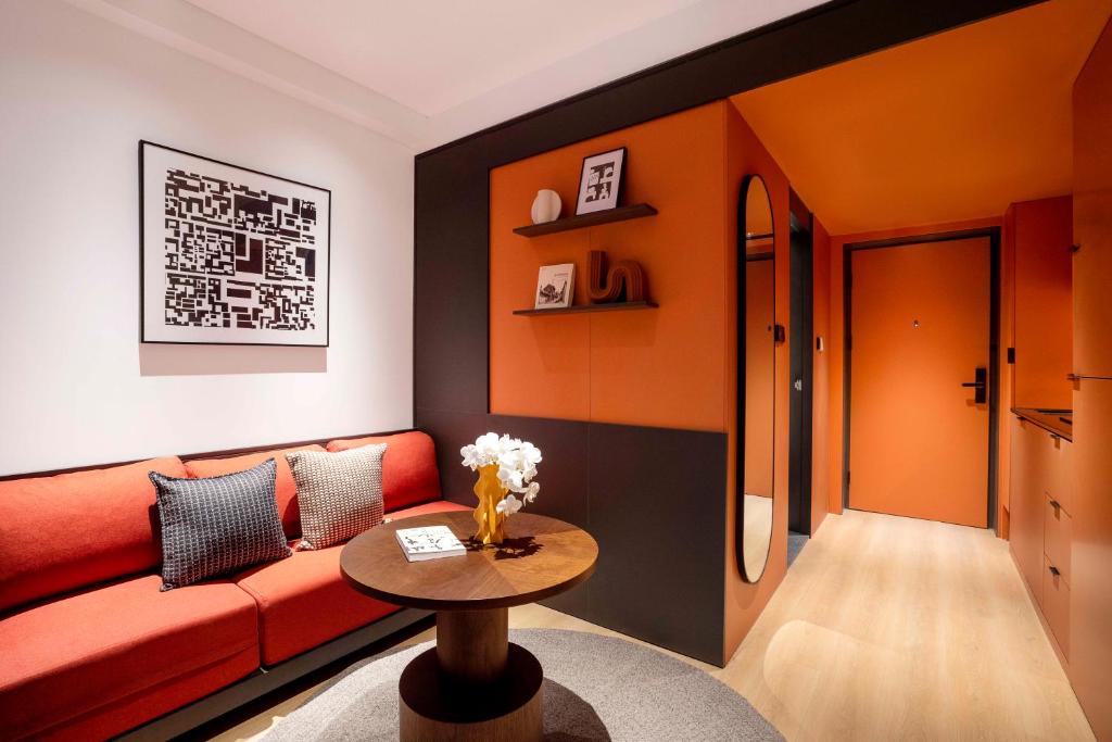 a living room with a red couch and a table at base-Beijing Wangfujing Serviced Apartment- in Hutong &Bike rental &Close to Forbidden City, Tian'anmen Square &Subway nearby &Free coffee &Washing machine,Kitchen &Restaurant discount &English speaking &High speed free WiFi in Beijing