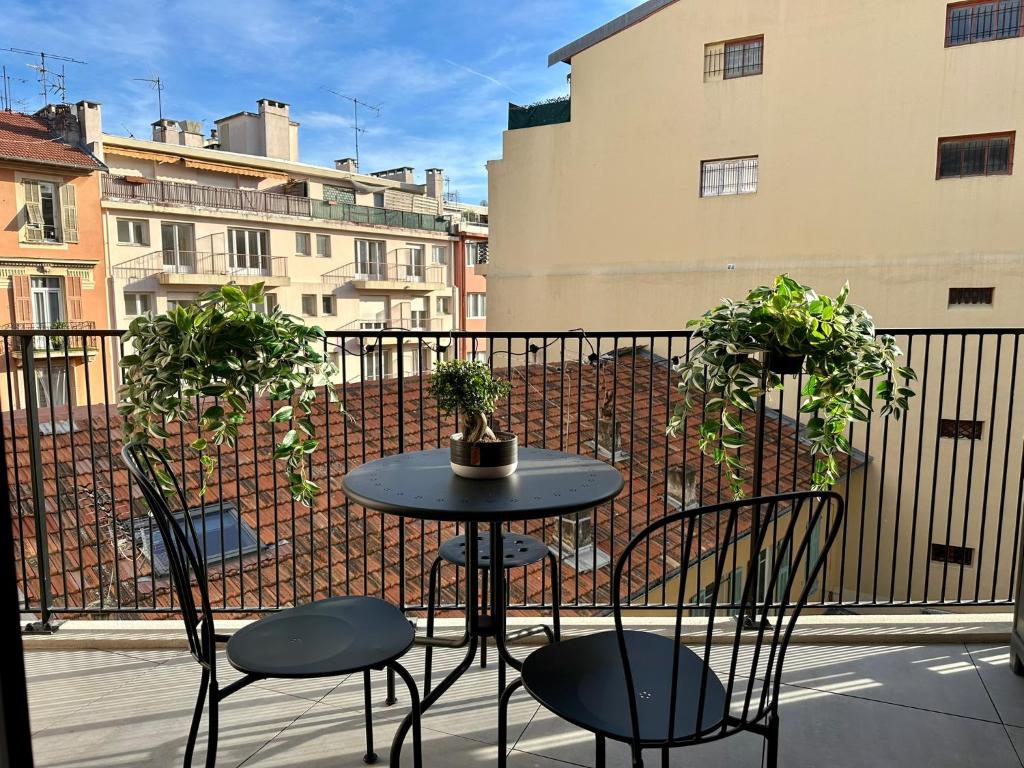 d'une table et de chaises sur un balcon orné de plantes. dans l'établissement Charmant Studio à proximité du Port de Nice, à Nice
