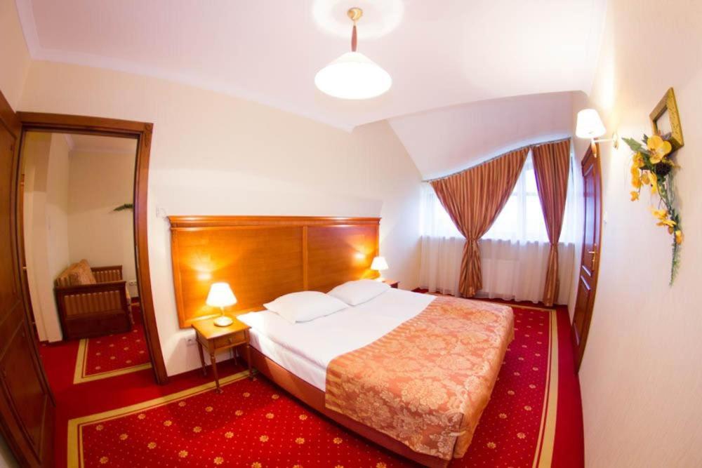 a hotel room with a bed and a window at Hotel Stodółka in Kielce